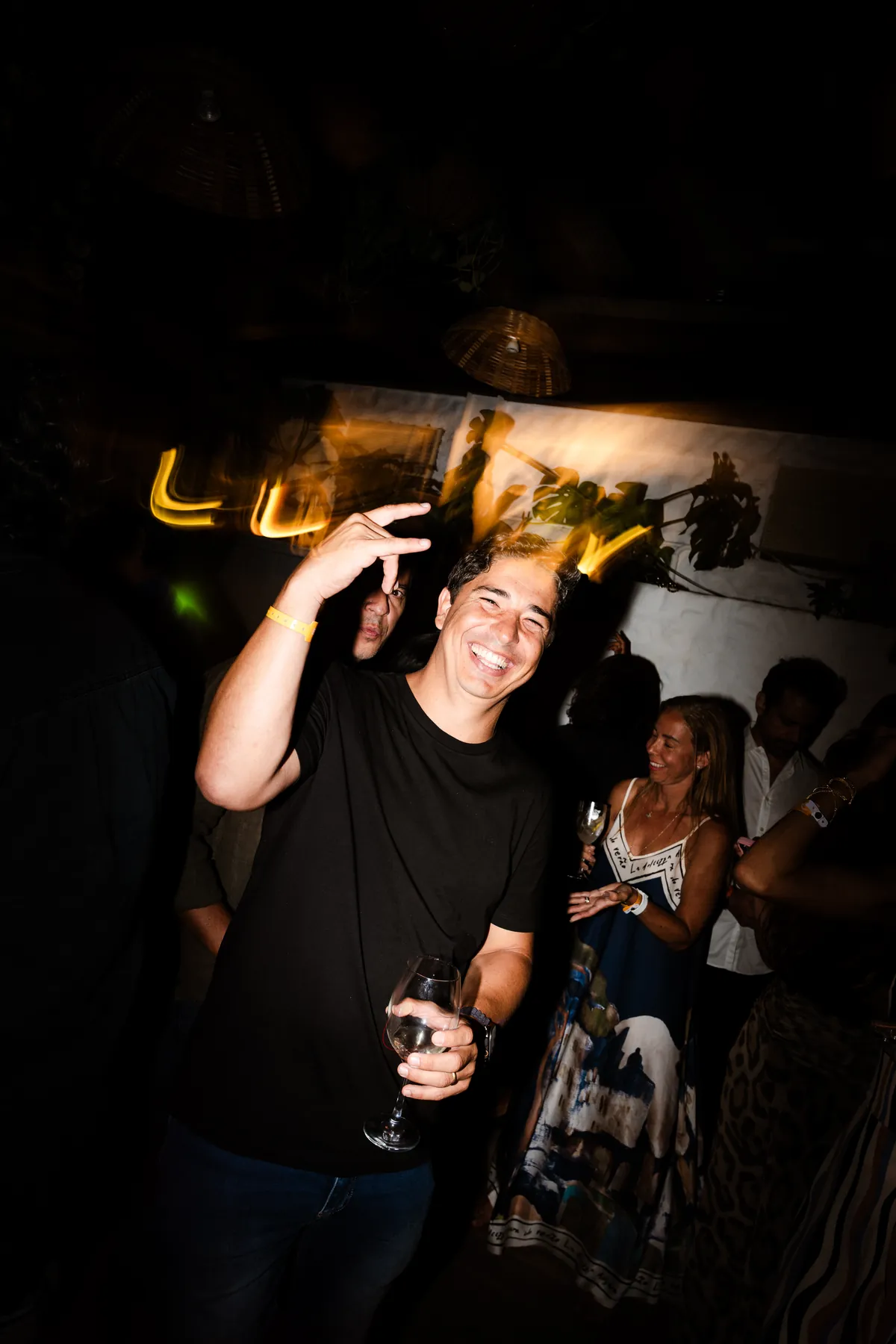 Ricardo sob um desenho de luz que forma a palavra Lucky